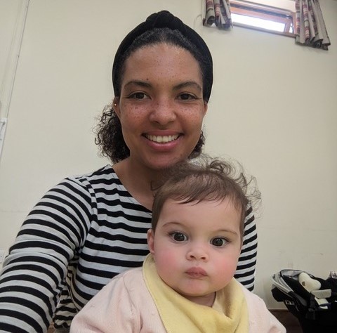 Smiling mum with baby that has just slept through the night